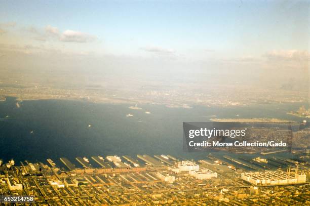 Aerial view facing west from Sunset Park and Red Hook, Brooklyn, across Upper New York Bay to the New Jersey shore of the Hudson River, 1957. At...