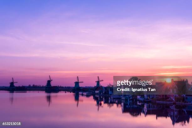 sunrise with windmills and houses at zaanstad, netherlands - ignatius tan stock pictures, royalty-free photos & images