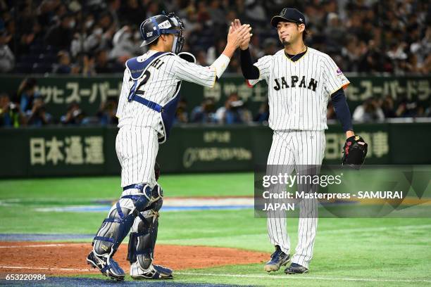 Pitcher Ryo Akiyoshi and Catcher Seiji Kobayashi of Japan high five after the top of the eighth inning during the World Baseball Classic Pool E Game...