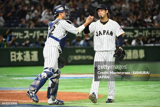 Pitcher Ryo Akiyoshi and Catcher Seiji Kobayashi of Japan high five after the top of the eighth inning during the World Baseball Classic Pool E Game...