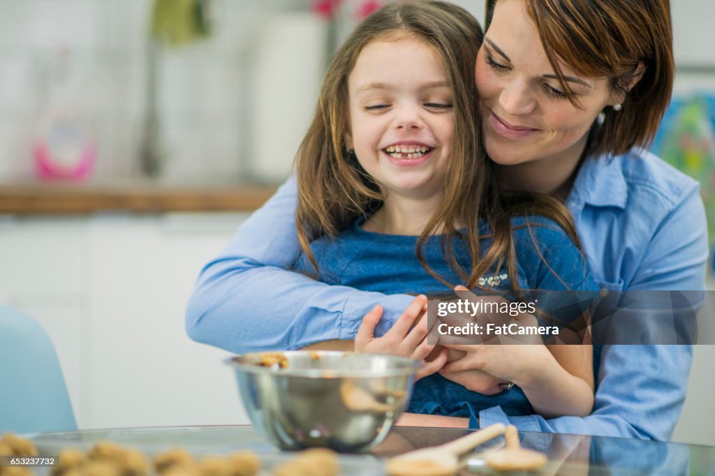 Madre enseñando su hija azada para hornear