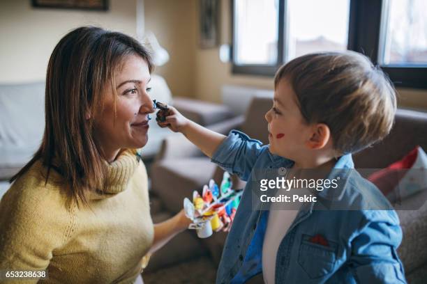 mother and son having fun with finger paint - pintura em têmpera imagens e fotografias de stock