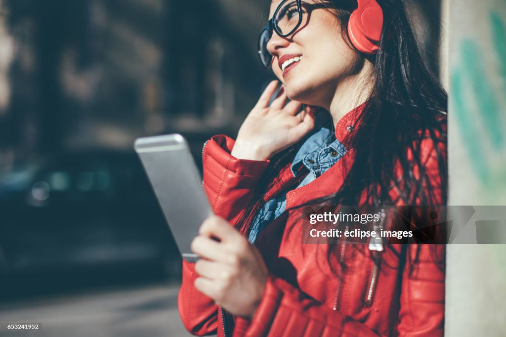 Pretty woman listening music with earphones from a phone