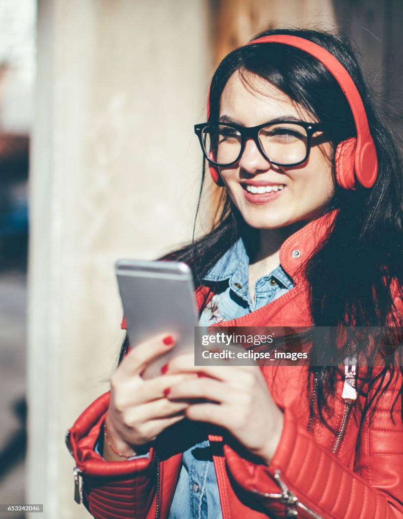 Pretty woman listening music with earphones from a phone