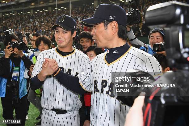 Designated hitter Tetsuto Yamada and Manager Hiroki Kokubo of Japan shake hands after the World Baseball Classic Pool E Game Four between Cuba and...