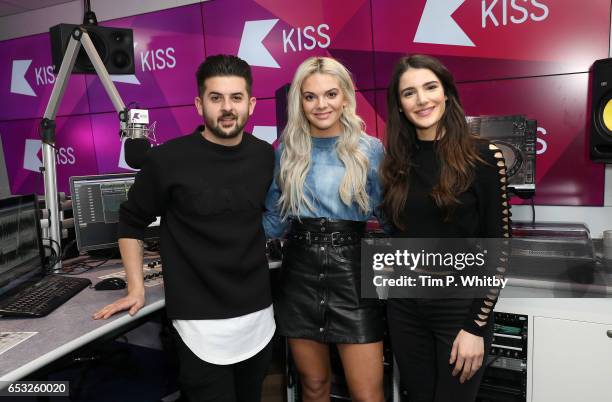 Louisa Johnson poses for photo with Kiss presenters Alex Mansuroglu and Andrea Zara during a visit to the Kiss FM studio on March 14, 2017 in London,...
