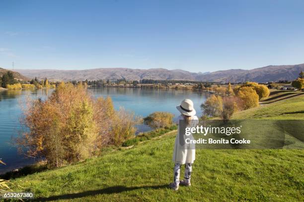 girl in hat and dress, looking at lake dunstan, in cromwell, central otago - lake dunstan stock pictures, royalty-free photos & images