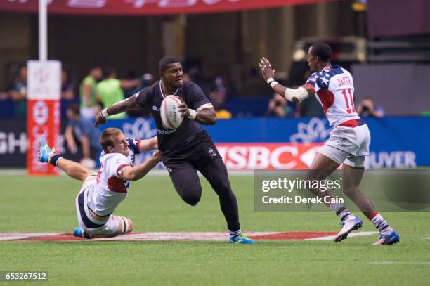 Masivesi Dakuwaqa of Fiji runs past Ben Pinkelman and Perry Baker of USA during day 2 of the 2017 Canada Sevens Rugby Tournament on March 12, 2017 in...