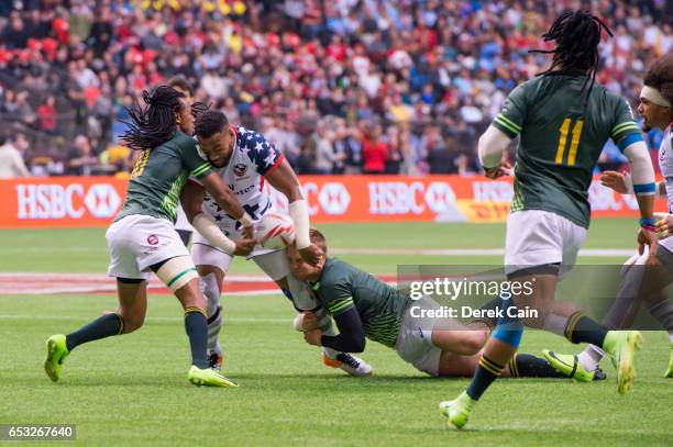 Andrew Durutalo of USA is tackled by Dylan Sage and Cecil Afrika of South Africa during day 2 of the 2017 Canada Sevens Rugby Tournament on March 12,...