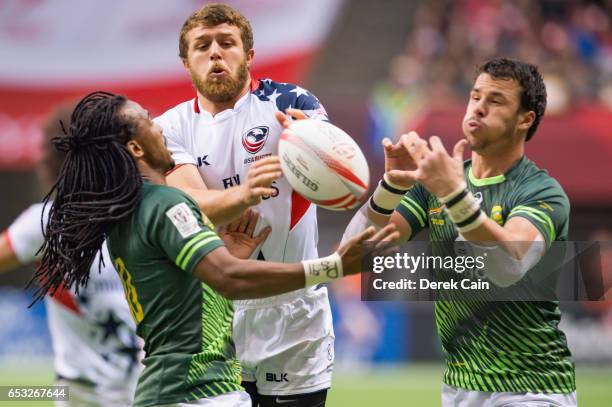 Stephen Tomasin of USA Cecil Afrika and Ruhan Nel of South Africa reach for the ball during day 2 of the 2017 Canada Sevens Rugby Tournament on March...