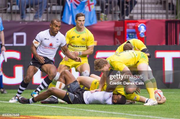 Mesulame Kunavula of Fiji lays under James Stannard of Australia as he places the ball behind him during day 2 of the 2017 Canada Sevens Rugby...