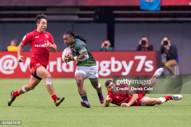 Cecil Afrika of South Africa breaks free from a tackle by Justin Douglas of Canada during day 2 of the 2017 Canada Sevens Rugby Tournament on March...