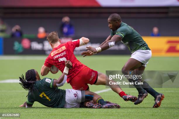 Lucas Hammond of Canada is tackled by Branco du Preez and Siviwe Soyizwapi of South Africa during day 2 of the 2017 Canada Sevens Rugby Tournament on...