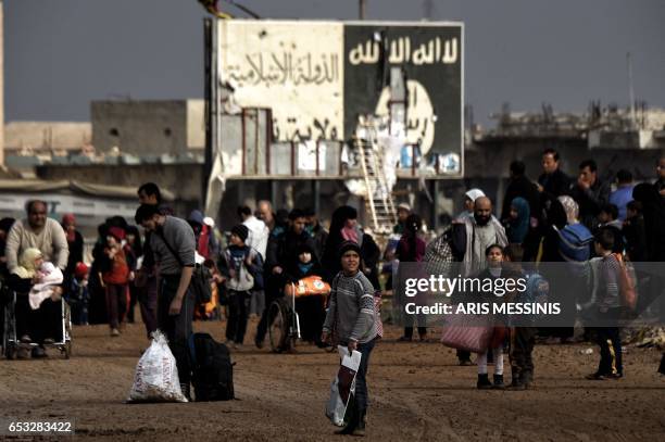 Displaced residents of western Mosul evacuate the city on March 14, 2017 as Iraqi government forces continue to advance in the embattled city...