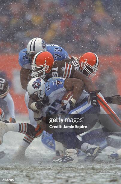 Marcus Spriggs of the Cleveland Browns tackles Eddie George of the Tennessee Titans during the game at the Cleveland Stadium in Cleveland, Ohio. The...