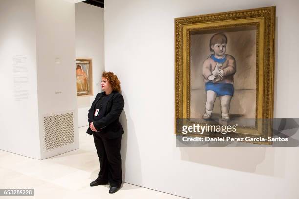 Museum staff member stands next to a painting by artist Pablo Picasso entitled 'Nio con juguete' on the opening day of the exhibition 'Pablo Picasso...