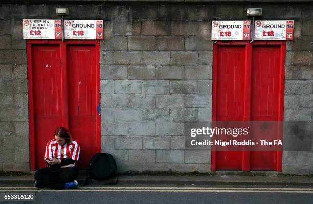 Lincoln City fan waits for the turnstiles to open ahead of the FA Trophy Semi Final, First Leg match between York City and Lincoln City at Bootham...