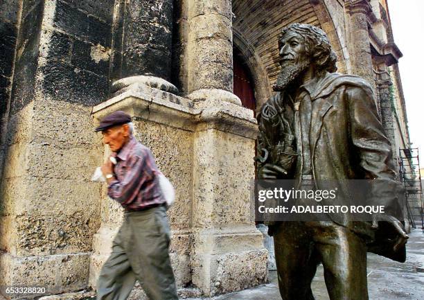 An old man is seen walking next to the "Caballero de Paris" statue in La Habana, Cuba 25 October 2001. Un anciano pasa el 25 de octubre de 2001, en...