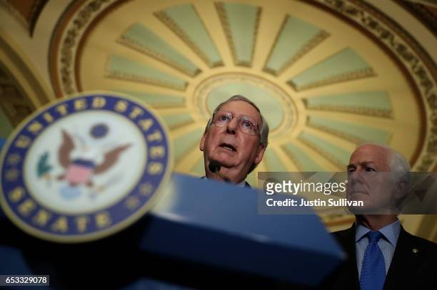 Senate Majority Leader Mitch McConnell speaks as Sen. John Cornyn looks on during a news conference on Capitol Hill on March 14, 2017 in Washington,...