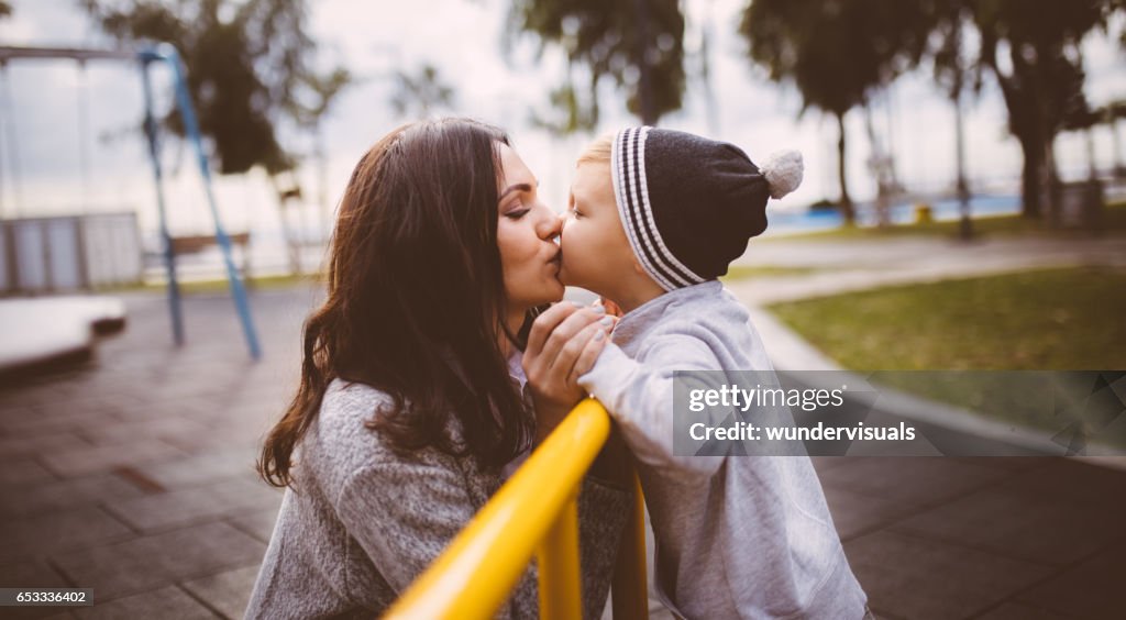 Son giving a kiss to his mother at the playground