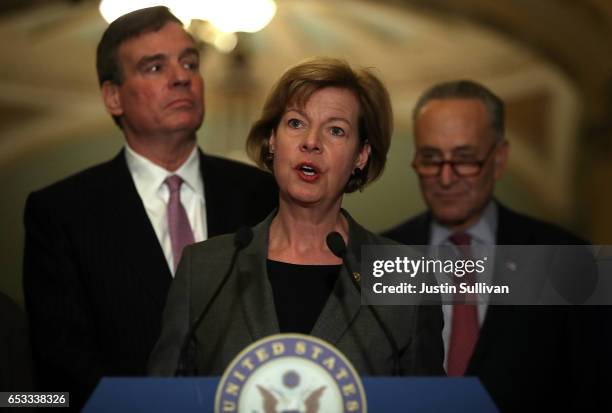 Sen. Tammy Baldwin speaks as Sen. Mark Warner and Senate Minority Leader Charles Schumer look during a news conference on Capitol Hill on March 14,...
