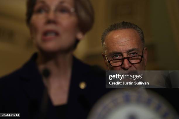 Senate Minority Leader Charles Schumer looks on as Sen. Elizabeth Warren speaks during a news conference on Capitol Hill on March 14, 2017 in...