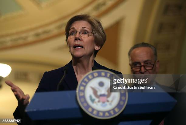 Sen. Elizabeth Warren speaks as Senate Minority Leader Charles Schumer looks on as during a news conference on Capitol Hill on March 14, 2017 in...
