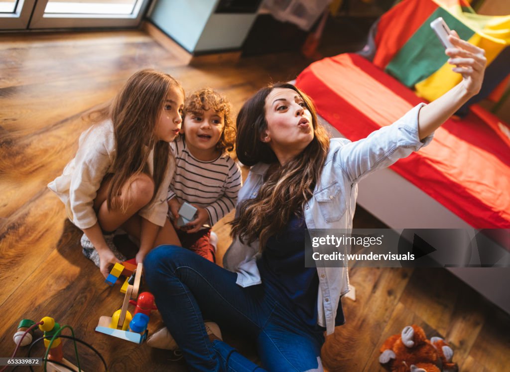 Giovane madre che si fa un selfie con il figlio e la figlia