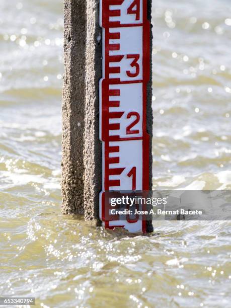 water level marker in a lagoon, a wind day and with waves in the water - bodenmarkierung stock-fotos und bilder
