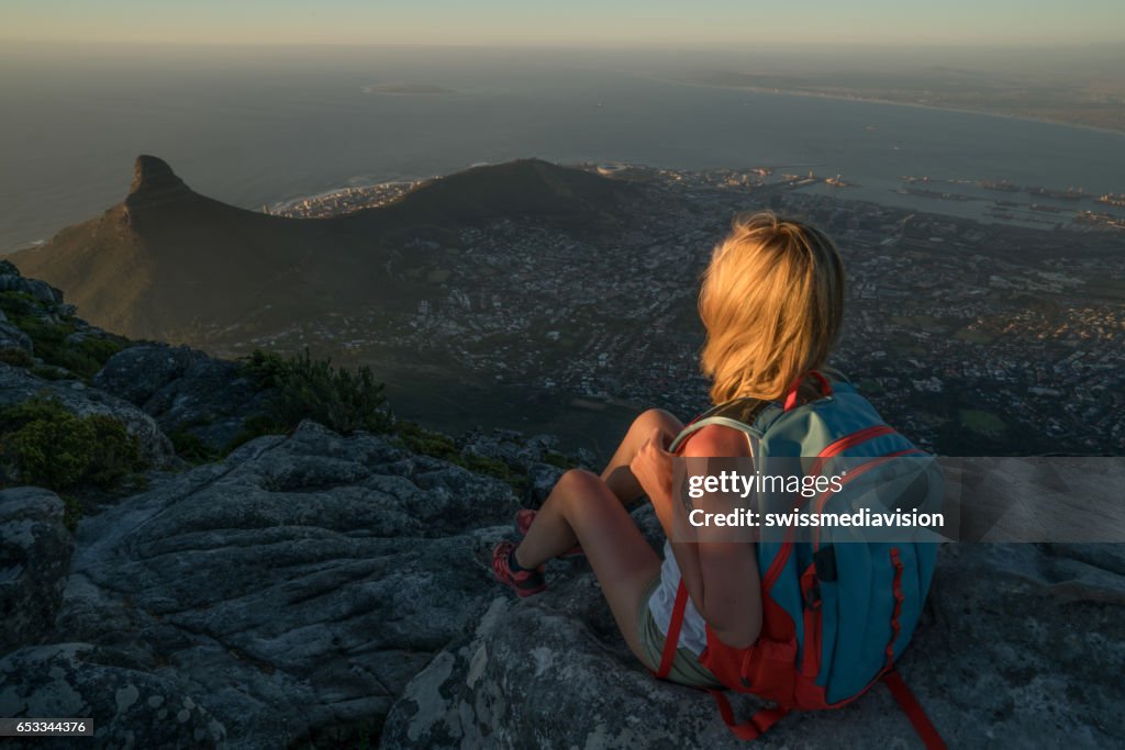 Young woman in Cape Town on top of mountain looking at view