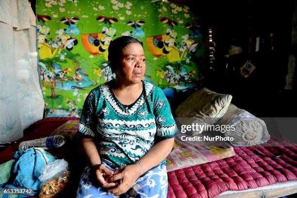 Nurtinah takes a break after working as a scavenger in her small hut. Nurtinah a farm worker from Pucang Anom village, Cerme sub-district, Bondowoso...