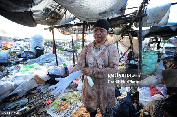 Nurtinah prepares to work as a scavenger. Nurtinah a farm worker from Pucang Anom village, Cerme sub-district, Bondowoso district, East Java...