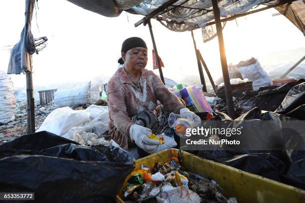 Nurtinah sorts the garbage. Nurtinah a farm worker from Pucang Anom village, Cerme sub-district, Bondowoso district, East Java Province, Indonesia...