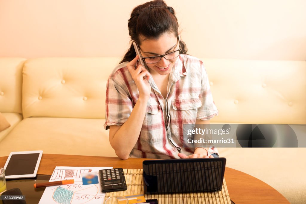 Junge Frauen, die Schreiben von Notizen während am Telefon