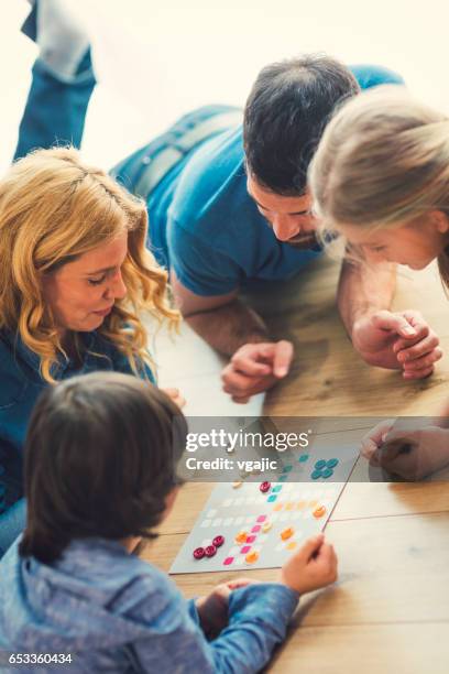 family playing board game at home - board games stock pictures, royalty-free photos & images