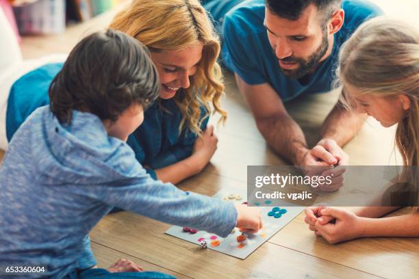 famille jouant au jeu de société chez vous - board game photos et images de collection