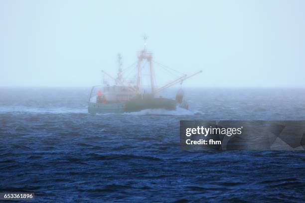 fishing boat on the sea in morning fog - north sea stock pictures, royalty-free photos & images