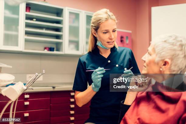rijpe vrouw op kantoor van de tandarts - mid volwassen vrouw stockfoto's en -beelden