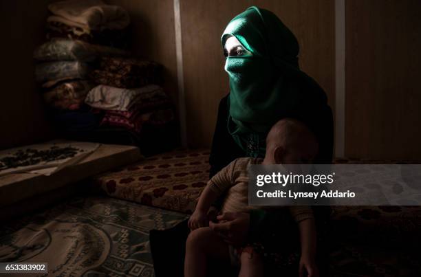 Yasmeen poses for a portrait with her baby months after leaving her abusive husband and returning home to live with her family at the Zaatari refugee...