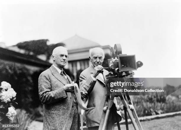 Inventor Thomas Edison and George Eastman poses for a portrait with a motion picture camera at Eastman's house in 1928 in Rochester, New York.