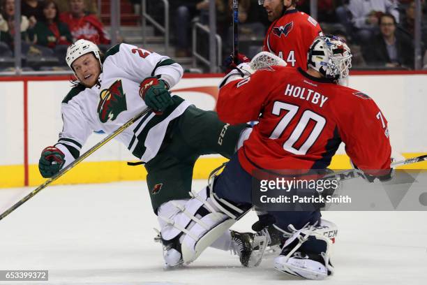 Ryan White of the Minnesota Wild collides with goalie Braden Holtby of the Washington Capitals during the first period at Verizon Center on March 14,...