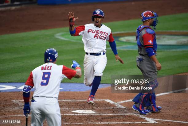 Francisco Lindor of Puerto Rico, center, is congratulated by Javier Baez after scoring during the first inning of World Baseball Classic Pool F Game...