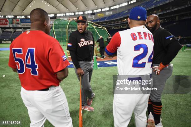 Outfielder Kalian Sams and Infielder Yurendell de Caster of the Netherlands talk with Outfielder Alfredo Despaigne and Designated hitter Frederich...