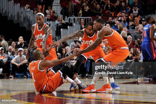 James Jones of the Cleveland Cavaliers is helped off the ground by teammates Iman Shumpert, Derrick Williams and DeAndre Liggins in the game against...