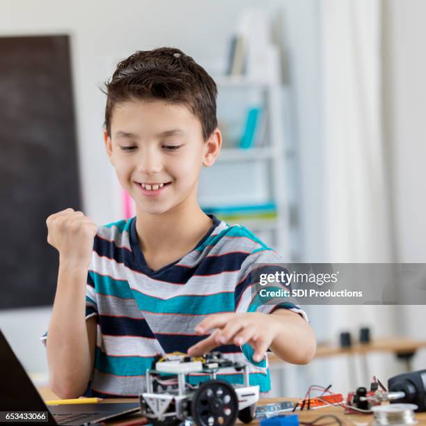 excited schoolboy finishes robot in science class - ganhos imagens e fotografias de stock