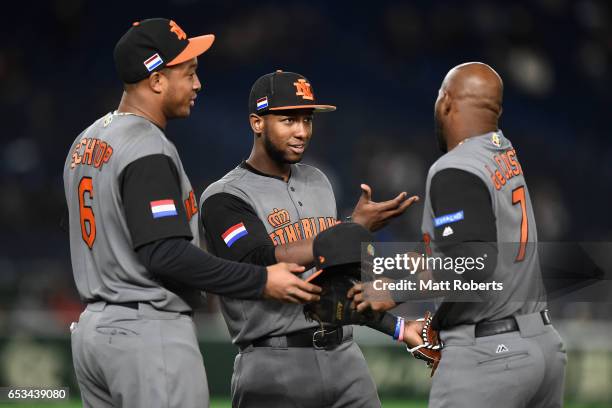 Infielder Yurendell de Caster of the Netherlands is congratulated by Infielder Jonathan Schoop and Outfielder Jurickson Profar after the top of the...