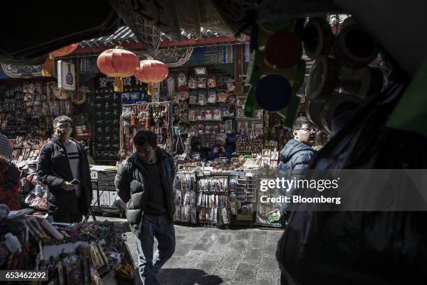 Pedestrians walk through a market street in the Wangfujing district of Beijing, China, on Tuesday, March 14, 2017. China has championed free trade...