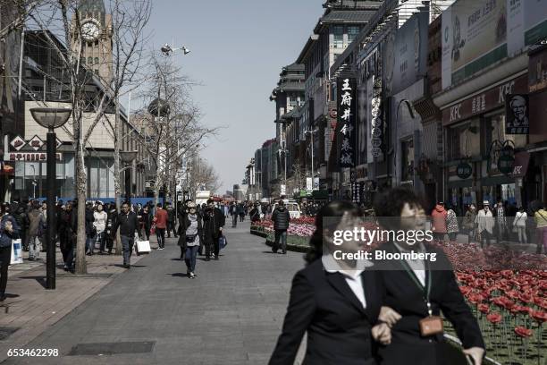 Pedestrians walk through a street in the Wangfujing district of Beijing, China, on Tuesday, March 14, 2017. China has championed free trade and...