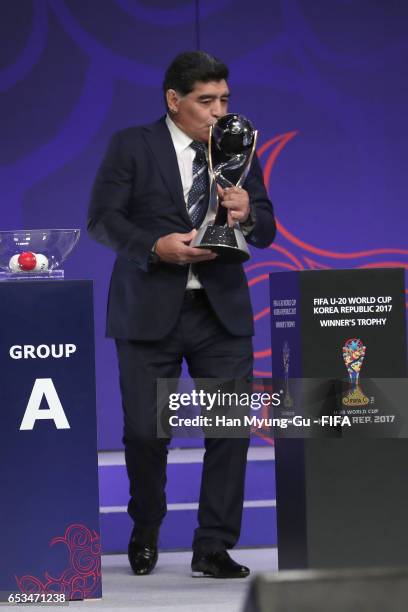 Diego Armando Maradona holds the FIFA U-20 World Cup trophy during the draw for the FIFA U-20 World Cup Korea Republic 2017 at Suwon SK Artrium on...