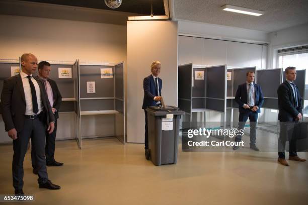 Close protection police officers surround Geert Wilders, the leader of the right-wing Party for Freedom , as he casts his vote during the Dutch...